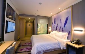 a bedroom with a large white bed and a desk at Lavande Hotel Wuhan Xudong Branch in Wuhan