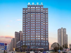 Un edificio alto con un cartel encima. en Lavande Hotel Lujiang Zhouyu Avenue, en Lujiang