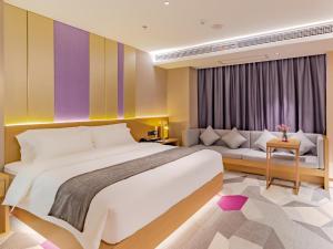 een hotelkamer met een groot bed en een bank bij Lavande Hotel Lujiang Zhouyu Avenue in Lujiang +43 foto's