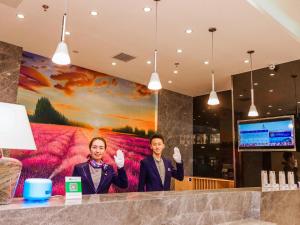 two men standing in front of a wall with their hands up at Lavande Hotel Zhangjiakou Victoria Plaza in Zhangjiakou +70 photos