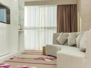 a living room with a couch and a large window at Lavande Hotels Xianning Tonghui Square Branch in Xianning