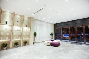 una hall con mobili viola e bianchi in un edificio di Lavande Hotel (Jingdezhen Taoxichuan Creative Square Branch) a Jingdezhen