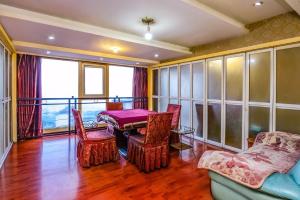 Una habitación con una mesa y sillas y un balcón. en 7Days Inn Chongqing Changshou Changshou Road, en Changshou