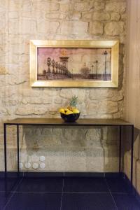 a painting on a wall with a bowl of fruit on a table at Pratic Hotel in Paris +57 photos