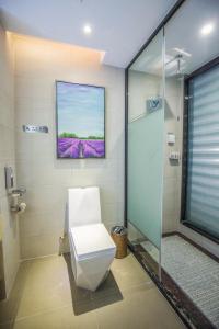 a bathroom with a toilet and a painting on the wall at Lavande Hotel Jiujiang Railway Station Branch in Jiujiang +36 photos