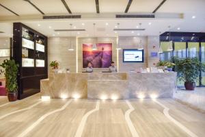 two people sitting at a reception desk in a lobby at Lavande Hotel (Liupanshui Ancient Town Branch) in Shuicheng