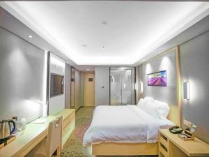 a bedroom with a large white bed and a desk at Lavande Hotel Nanchang Bayi Square Branch in Nanchang