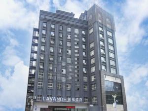 ein großes graues Gebäude mit einem Schild drauf in der Unterkunft Lavande Hotel Nanchang Bayi Square Branch in Nanchang