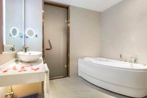 une salle de bain avec une baignoire blanche et un lavabo dans l'établissement Lavande Hotel (Nanchang Liantang Xiaolan Industrial Park Branch), à Nanchang 35 autres photos