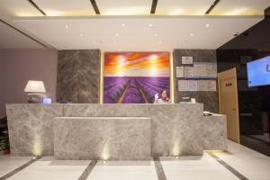 a lobby with a large painting on the wall at Lavande Hotel Xuzhou West Exit of High Speed Rail Station Branch in Xuzhou