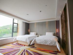 a bedroom with two beds and a large window at Lavande Hotel (Gaozhou Chengdong Bus Station Branch) in Maoming
