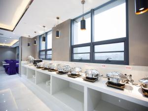 a row of silver dishes on a counter in a restaurant at Lavande Hotel (Yingtan Longhushan Avenue Branch) in Yingtan