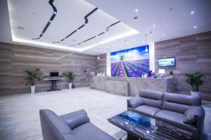 a lobby with couches and a tv in a building at Lavande Hotel Jiujiang Railway Station Branch in Jiujiang