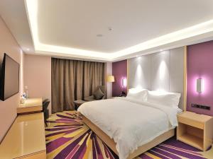 um quarto de hotel com uma cama grande e um sofá em Lavande Hotel (Siping Wanda Plaza Branch) em Siping