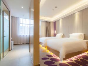 a hotel room with two beds and a mirror at Lavande Hotel (Chengde Mountain Resort Waiba Temple Branch) in Chengde +34 photos