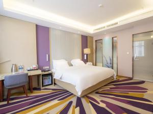 um quarto com uma grande cama branca e uma secretária em Lavande Hotel(Macheng High-speed Station Branch) em Macheng