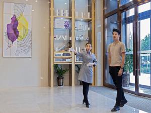 a man and a woman standing in a room at Lavande Hotel Handan Congtai Park New Century Plaza in Handan