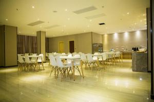 une salle à manger avec des tables et des chaises blanches dans l'établissement Lavande Hotel Sihong Bus Terminal Zhongyuan Logistics City Branch, à Sihong