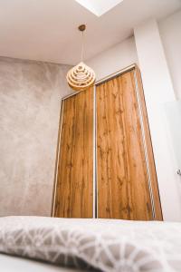 Una puerta de madera en un dormitorio con cama en Apartmán ZA-KA 2 ubytování Litovel, en Červenka
