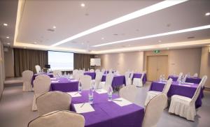 una habitación con mesas púrpuras y sillas blancas y una habitación con mesas púrpuras y blanco en Lavande Hotel (Changchun Yiqi Branch), en Changchún