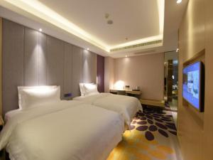 ein Hotelzimmer mit 2 Betten und einem Flachbild-TV in der Unterkunft Lavande Hotel Changchun Hangkong University Fanrong Road Metro Station in Changchun