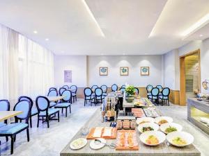 a dining room with a long table and chairs at Lavande Hotel (Shenyang Olympic Center Wanda Branch) in Shenyang