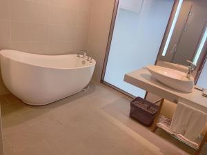 bagno con ampia vasca e lavandino di Lavande Hotel (Fuzhou Wanda Branch) a Fuzhou