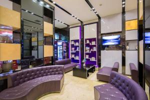 una sala de espera con sofás morados y TV en Lavande Hotel Changsha Pedestrian Street Nanmenkou Metro Station Branch, en Changsha