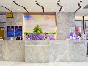 a lobby with a large painting on the wall at Lavande Hotel Xuzhou New Town Midea Plaza in Xuzhou