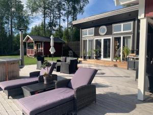 a patio with couches and a table and a house at Galasjön 132 in Mellansel