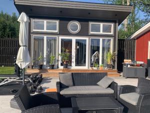 a patio with a couch and chairs and an umbrella at Galasjön 132 in Mellansel +10 photos