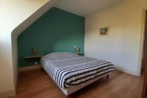 een slaapkamer met een bed en een groene muur bij Gîte de charme 14 personnes labellisé Clévacances 3 étoiles in Sainte-Sève
