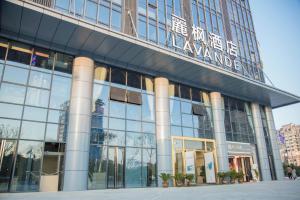 um grande edifício de vidro com uma placa em Lavande Hotels Xianning Tonghui Square Branch em Xianning