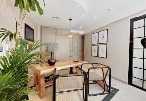 Don Cesar Boutique Apartments في بنيدورم: غرفة طعام مع طاولة وكراسي خشبية