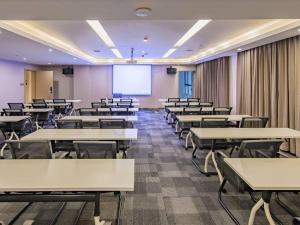 an empty lecture room with tables and a projection screen at Lavande Hotel Nanchang Shuanggang Metro Station Caida University in Nanchang