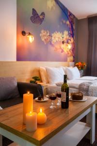 a living room with a table with a bottle of wine and candles at Etude Hotel in Lviv