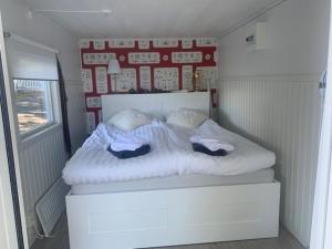 a small bedroom with a white bed with two pillows at Galasjön 132 in Mellansel