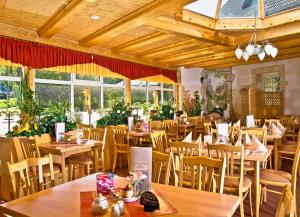 a restaurant with wooden tables and chairs and windows at Land-gut-Hotel Cafe Meier in Oybin