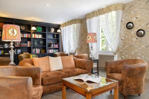 uma sala de estar com um sofá e uma mesa em Logis Domaine De Valaudran em Salbris
