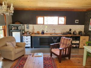 a kitchen with a couch and a chair and a table at Shepherd's Cottage in Nieu-Bethesda