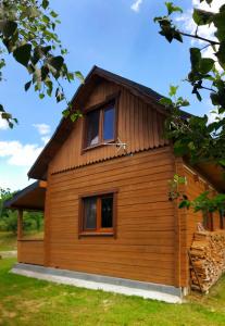 a wooden house with two windows on the side of it at Domek w Beskidach in Ropica Górna