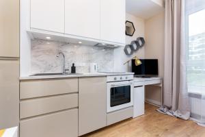 een witte keuken met een wastafel en een fornuis bij Mokotow Business Center Apartments by Renters in Warschau