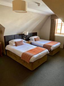 a hotel room with two beds and two lamps at The Dutch Mill Hotel in Aberdeen