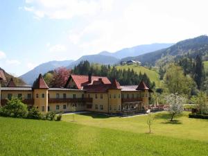 a large building in a field with mountains in the background at Hotel Waldesruh in Göstling an der Ybbs