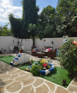 a patio with a garden with a couch and chairs at Angela - Zoi Rooms in Skiathos Town