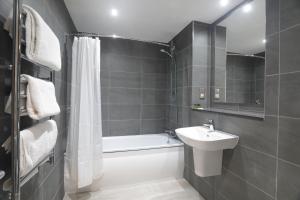 a bathroom with a sink, toilet and bathtub at The Isles of Glencoe Hotel in Glencoe