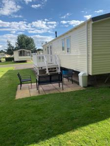 two benches sitting on a patio next to a house at Seton sands static holiday home - sleeps 6 in Port Seton