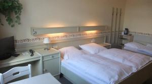 a bedroom with a bed and a desk with a lamp at Hotel Kniep in Bockenem