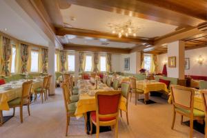 uma sala de jantar com mesas e cadeiras e um lustre em Hotel Palin em Ischgl
