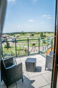 a balcony with chairs and a view of a park at The Chase Golf & Country Club in Penkridge